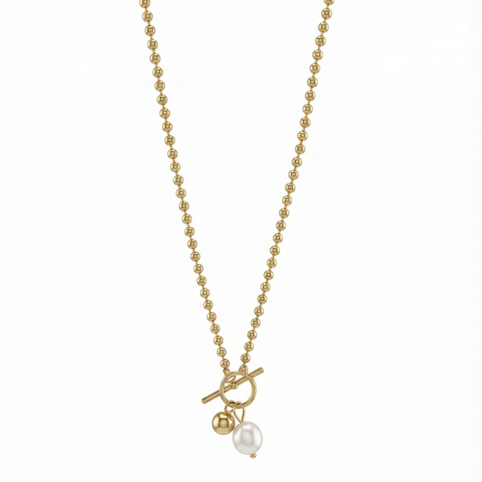 Détail du fermoir toggle et perle nacrée du collier doré