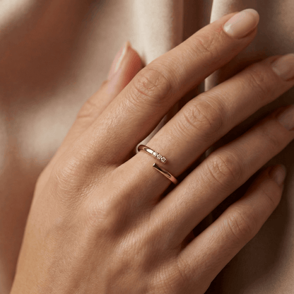 Bague dorée à l’or 18k ouverte, sertie de trois pierres blanches, design épuré, diamètre 1,7 cm, usage quotidien