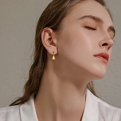Boucles d’oreilles clous dorées pour femme en acier inoxydable, au design goutte d’eau lisse et poli miroir. Bijou chic et intemporel au style minimaliste et contemporain, hypoallergénique et résistant à l’eau, parfait pour un look raffiné au quotidien