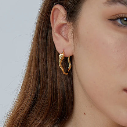 Boucles d’oreilles créoles dorées pour femme en plaqué or, représentant un serpent enroulé aux courbes ondulantes et finition brillante effet écailles. Bijou symbolique et puissant au style bohème, mystique et rock, idéal pour affirmer sa personnalité