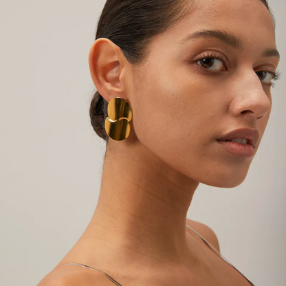 Boucles d’oreilles puces dorées pour femme en acier inoxydable, au design organique et sculptural inspiré de pétales fusionnés. Bijou arty et moderne au fini miroir, résistant à l’eau et hypoallergénique, idéal pour un look élégant ou de cérémonie