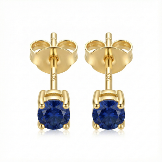 Boucles d'oreilles puces en argent doré avec pierre zircon couleur saphir bleu roi, style joaillerie élégant.