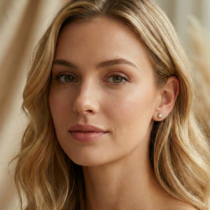 Boucles d'oreilles puces en forme de soleil en argent 925 doré à l'or fin, serties d'un zircon central brillant.