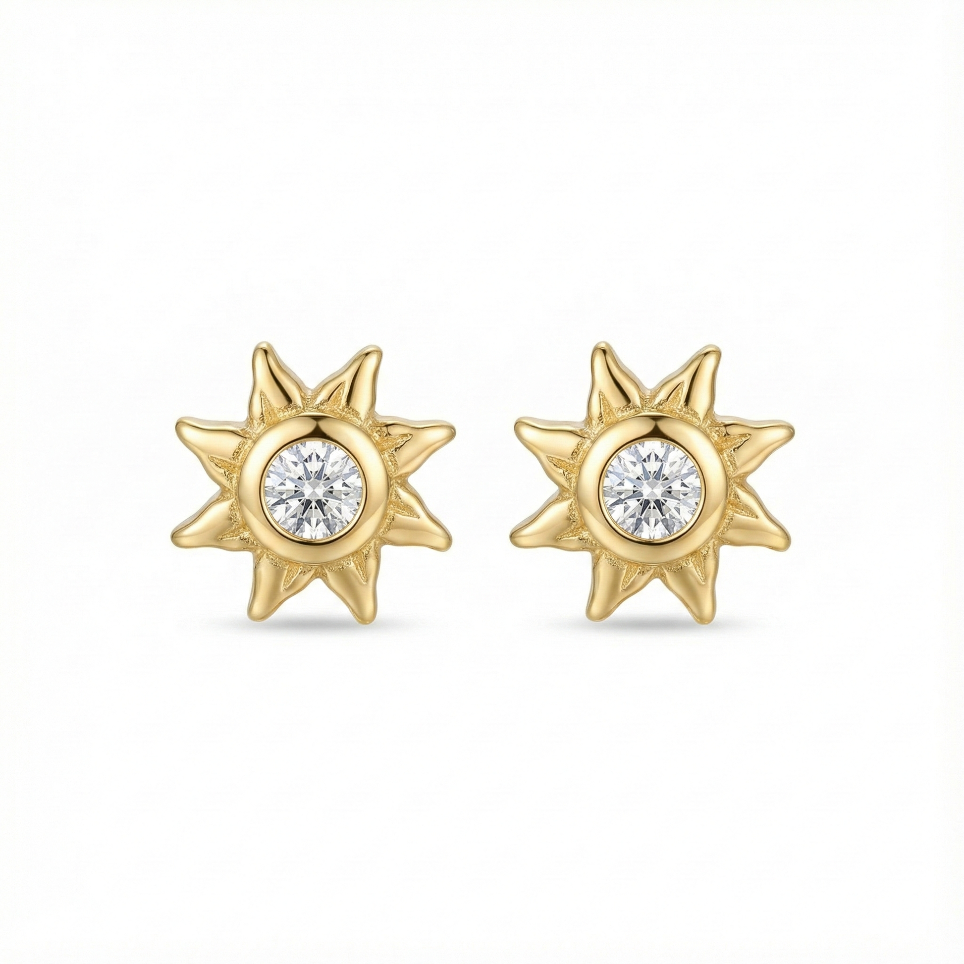 Boucles d'oreilles puces en forme de soleil en argent 925 doré à l'or fin, serties d'un zircon central brillant.