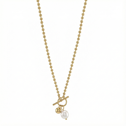 Détail du fermoir toggle et perle nacrée du collier doré